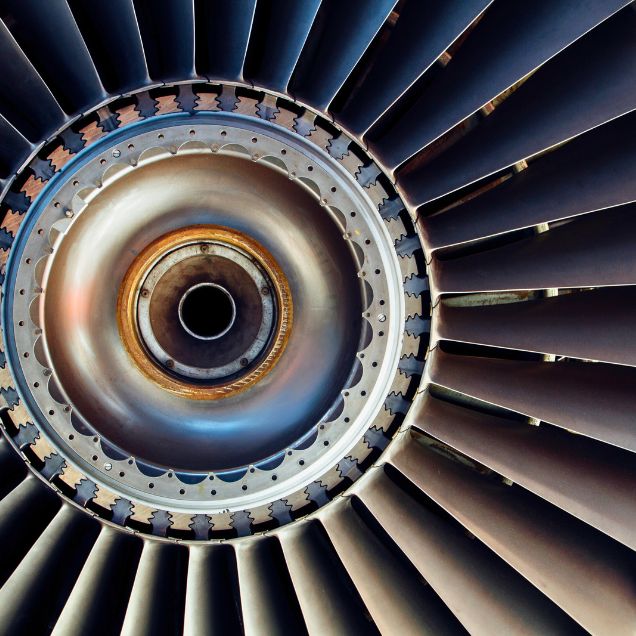 Vue rapprochée d'une turbine d'avion, mettant en valeur les pales et les détails métalliques, symbolisant la précision de l'industrie aéronautique.